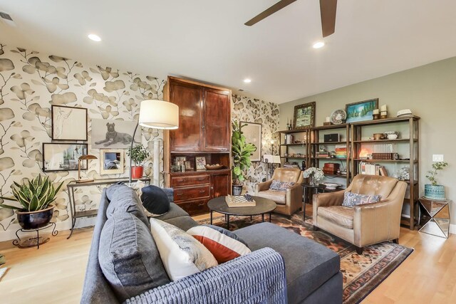 living room featuring light wood-type flooring, a ceiling fan, and recessed lighting