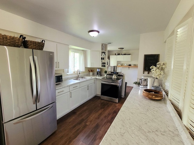 kitchen featuring stainless steel appliances, a sink, open shelves, white cabinetry, and dark wood-style flooring