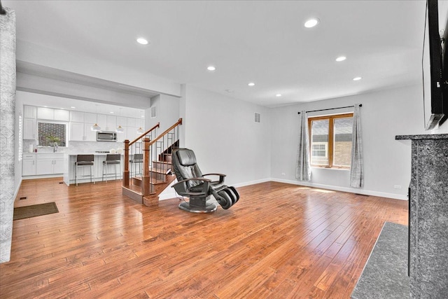 7439 W Lunt Ave, Chicago, IL 60631 - unfurnished living room with plenty of natural light, light wood-style floors, stairs, recessed lighting, and baseboards