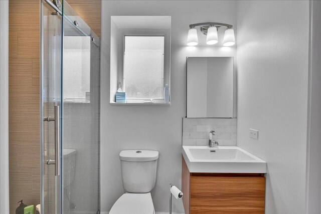 7439 W Lunt Ave, Chicago, IL 60631 - bathroom featuring toilet, a stall shower, vanity, and backsplash