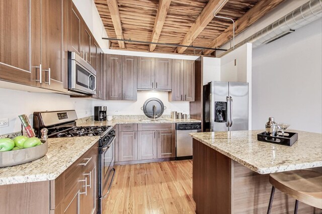 770 W Gladys Ave Unit 204, Chicago, IL 60661 - kitchen featuring stainless steel appliances, light wood-type flooring, a kitchen breakfast bar, wooden ceiling, and beamed ceiling