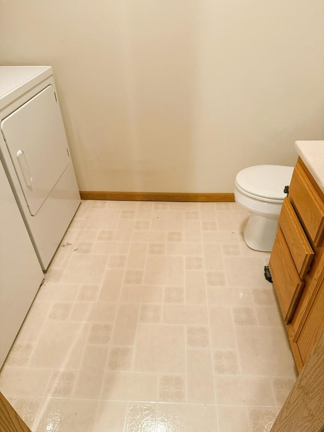 1004 N Hill Dr, Dixon, IL 61021 - bathroom with baseboards, washer / clothes dryer, vanity, and toilet