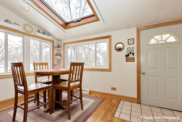 41551 N Lotus Ave, Antioch, IL 60002 - dining space with light wood finished floors, vaulted ceiling, a skylight, and baseboards