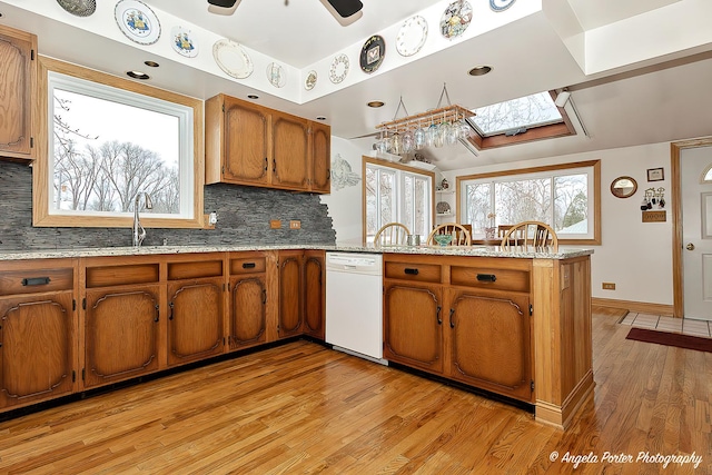 41551 N Lotus Ave, Antioch, IL 60002 - kitchen featuring dishwasher, a skylight, a peninsula, light wood finished floors, and brown cabinetry