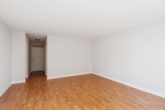 unfurnished room featuring light wood finished floors and baseboards