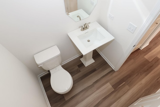 bathroom with toilet, wood finished floors, and baseboards
