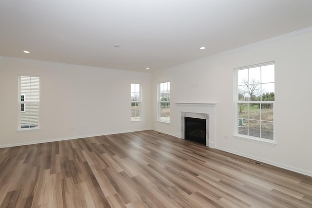 unfurnished living room featuring crown molding, a fireplace, light wood-style floors, recessed lighting, and baseboards