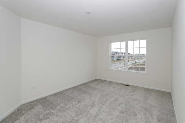 carpeted empty room featuring baseboards