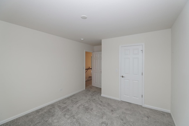 unfurnished bedroom featuring carpet floors and baseboards