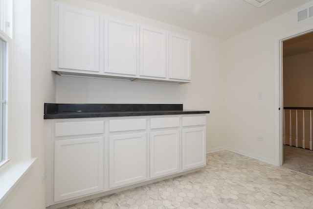 kitchen featuring white cabinetry and dark countertops