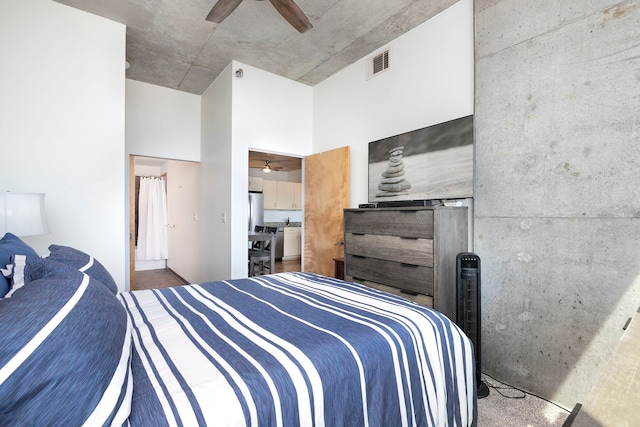 bedroom featuring a high ceiling, a ceiling fan, and freestanding refrigerator