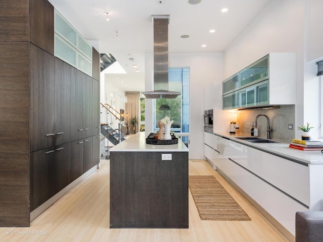 1729 W Potomac Ave, Chicago, IL 60622 - kitchen featuring modern cabinets, a kitchen island, light wood finished floors, island exhaust hood, and recessed lighting