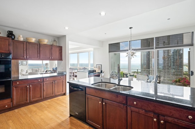 445 E N Water St Unit 2105, Chicago, IL 60610 - kitchen featuring black appliances, light wood-style floors, dark stone counters, hanging light fixtures, and recessed lighting