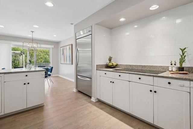 3726 Pebble Beach Rd, Northbrook, IL 60062 - kitchen with stainless steel built in fridge, black electric cooktop, white cabinets, light wood-style floors, and baseboards