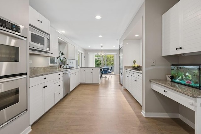 3726 Pebble Beach Rd, Northbrook, IL 60062 - kitchen with built in appliances, a peninsula, light wood finished floors, white cabinets, and recessed lighting