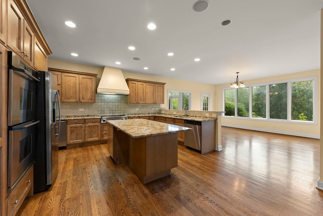 1161 Gavin Ct, Lake Forest, IL 60045 - kitchen with stainless steel appliances, custom exhaust hood, a peninsula, a sink, and brown cabinetry