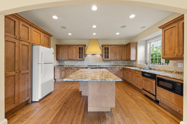 1161 Gavin Ct, Lake Forest, IL 60045 - kitchen featuring freestanding refrigerator, premium range hood, paneled dishwasher, brown cabinetry, and black microwave