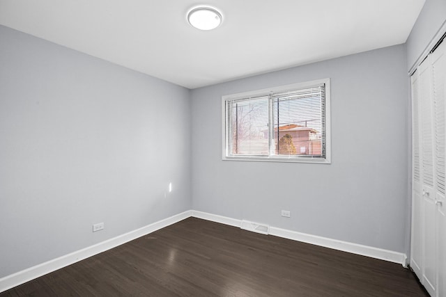 16779 92nd Ave, Orland Hills, IL 60487 - unfurnished bedroom with dark wood-style floors, a closet, and baseboards