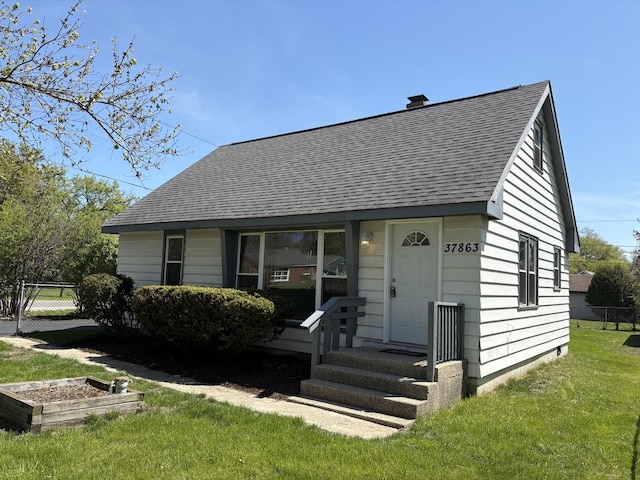 view of front of home featuring roof with shingles and a garden