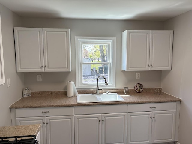 kitchen with a sink and white cabinetry
