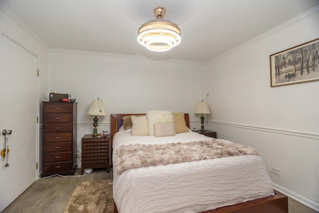 bedroom featuring ornamental molding and wood finished floors