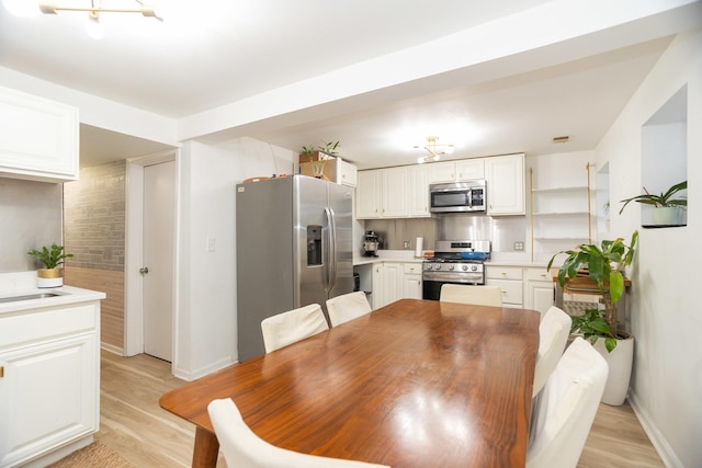 dining room featuring light wood finished floors and baseboards