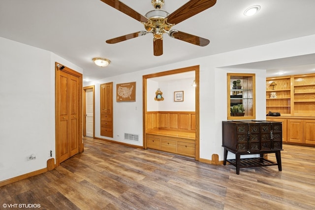 202 W Tanglewood Dr, Arlington Heights, IL 60004 - living area with light wood-style floors, ceiling fan, built in shelves, and a wainscoted wall