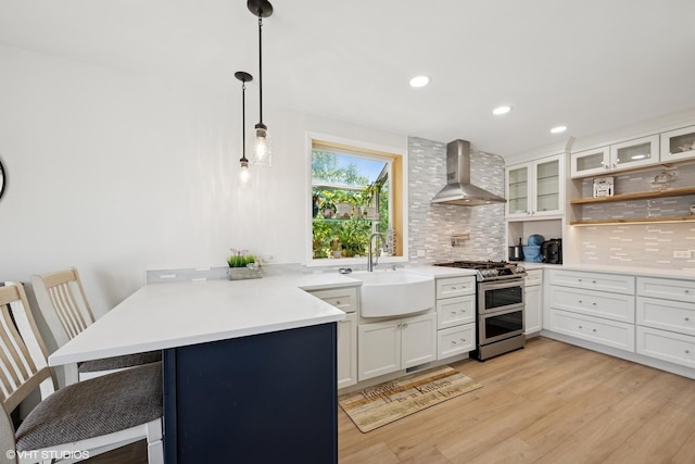 202 W Tanglewood Dr, Arlington Heights, IL 60004 - kitchen with range with two ovens, wall chimney range hood, a peninsula, decorative backsplash, and glass insert cabinets