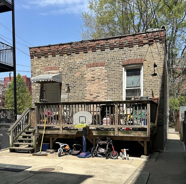 view of front facade featuring a wooden deck and brick siding