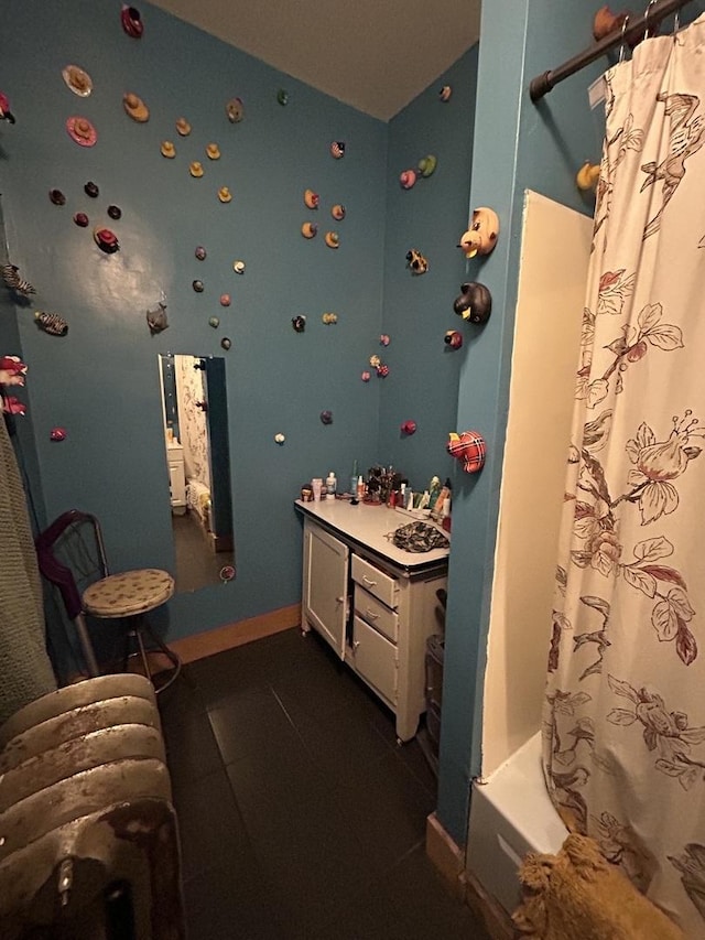 bathroom featuring shower / bathtub combination with curtain, vanity, and tile patterned flooring