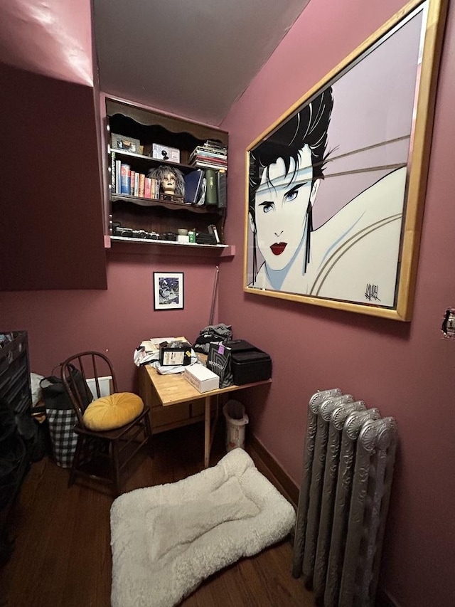 home office with radiator heating unit and wood finished floors