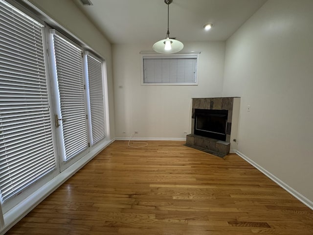 unfurnished living room featuring a fireplace, baseboards, light wood-style flooring, and recessed lighting