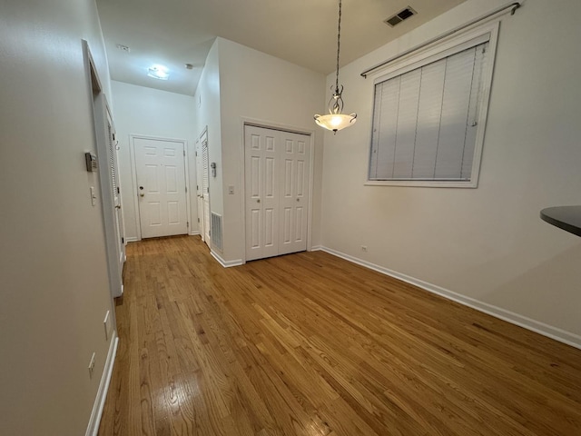 unfurnished dining area with wood finished floors and baseboards