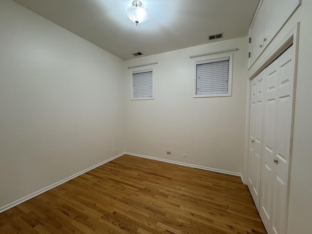 spare room with wood finished floors and baseboards