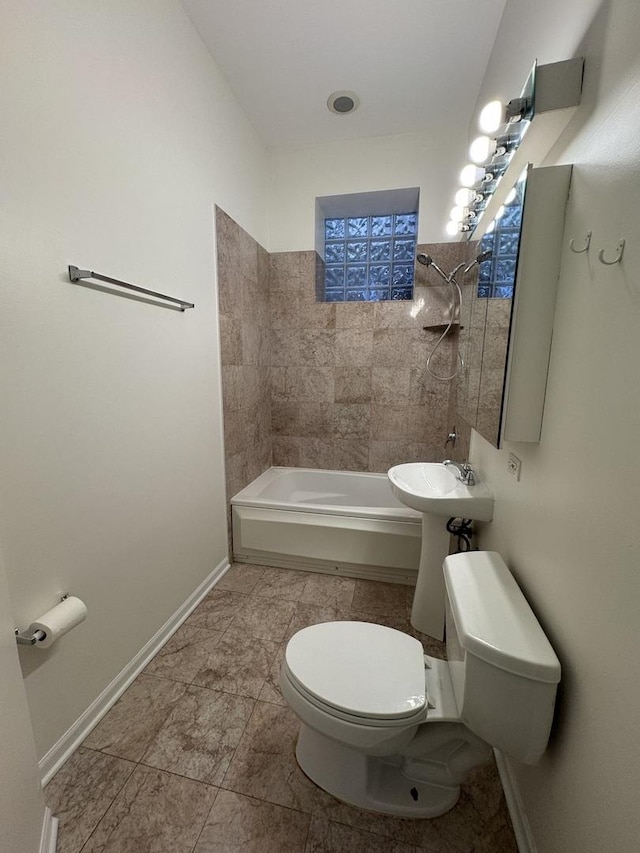 bathroom with toilet, baseboards, shower / bath combination, and tile patterned floors