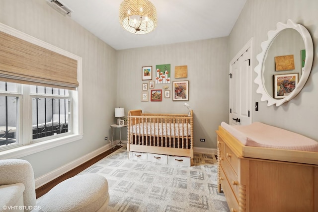 bedroom with baseboards, a chandelier, and light wood-style flooring