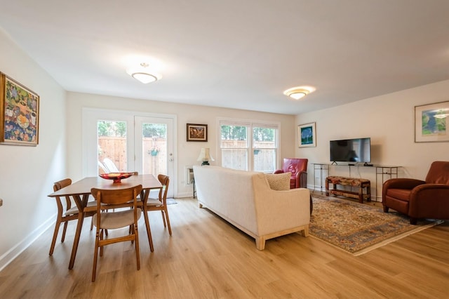 living area with light wood-style flooring and baseboards