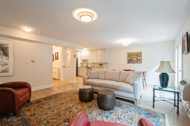 living area featuring light wood finished floors and baseboards