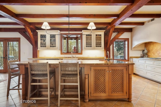 236 Steeplechase Rd, Barrington Hills, IL 60010 - kitchen with a sink, light tile patterned floors, beamed ceiling, an island with sink, and pendant lighting