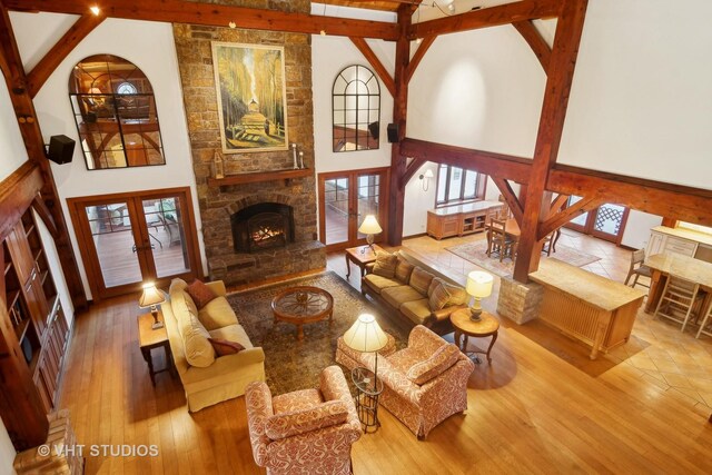 236 Steeplechase Rd, Barrington Hills, IL 60010 - living room with french doors, a stone fireplace, beamed ceiling, wood finished floors, and a towering ceiling