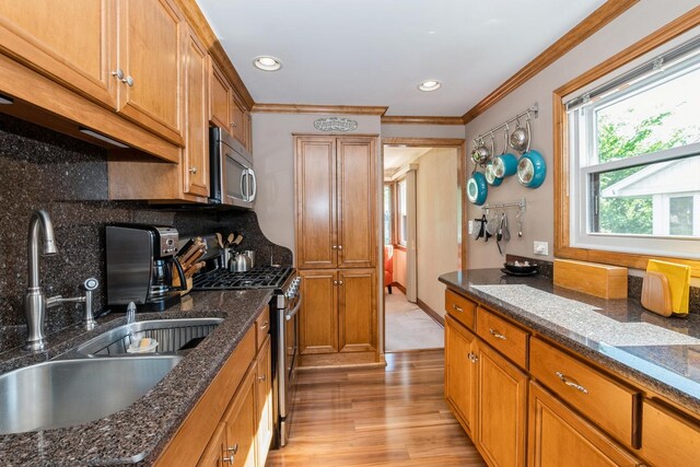4904 Spring Rd, Oak Lawn, IL 60453 - kitchen with stainless steel appliances, brown cabinets, ornamental molding, light wood-style floors, and backsplash