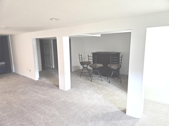 carpeted dining room featuring a dry bar