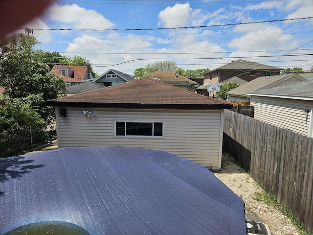 view of side of home featuring fence and roof with shingles