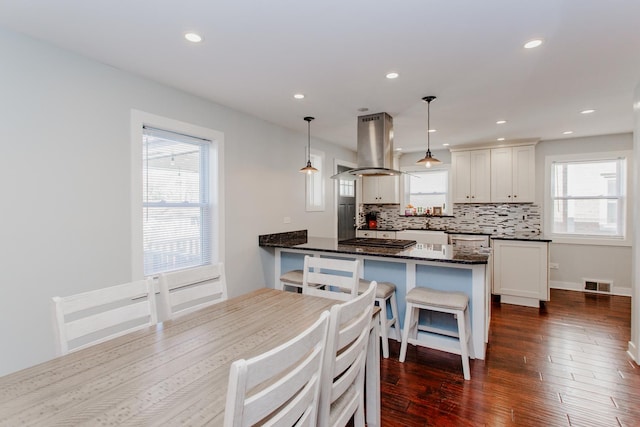 5236 N Mobile Ave, Chicago, IL 60630 - kitchen with island range hood, a peninsula, tasteful backsplash, gas cooktop, and white cabinetry