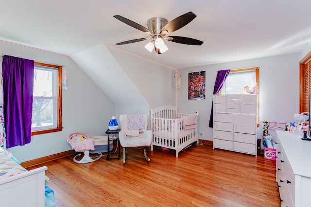 5236 N Mobile Ave, Chicago, IL 60630 - bedroom featuring multiple windows, light wood finished floors, vaulted ceiling, baseboards, and a ceiling fan