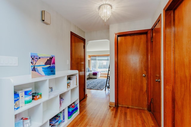 5236 N Mobile Ave, Chicago, IL 60630 - hallway featuring light wood-type flooring and a chandelier