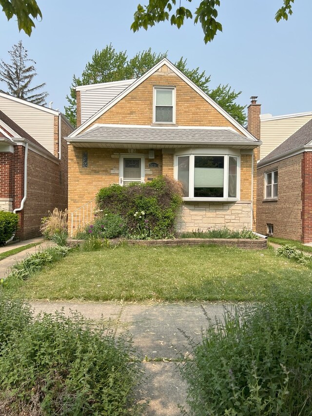 5236 N Mobile Ave, Chicago, IL 60630 - bungalow-style house with a front yard and brick siding
