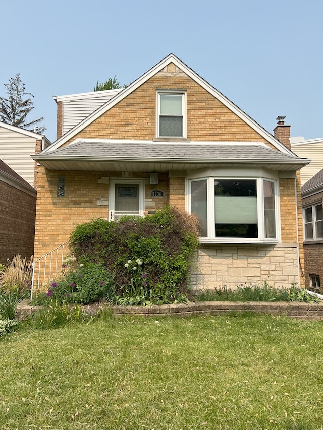 5236 N Mobile Ave, Chicago, IL 60630 - view of front of house featuring a front yard, brick siding, and roof with shingles