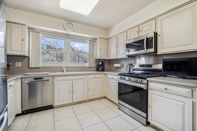 210 Constance Ln, Northbrook, IL 60062 - kitchen with appliances with stainless steel finishes, a sink, light tile patterned floors, light countertops, and decorative backsplash