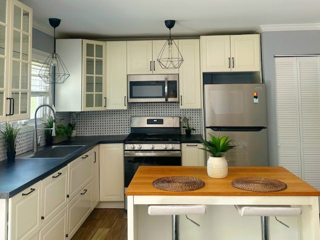 620 Teton Cir, Carol Stream, IL 60188 - kitchen with appliances with stainless steel finishes, a sink, ornamental molding, hanging light fixtures, and decorative backsplash